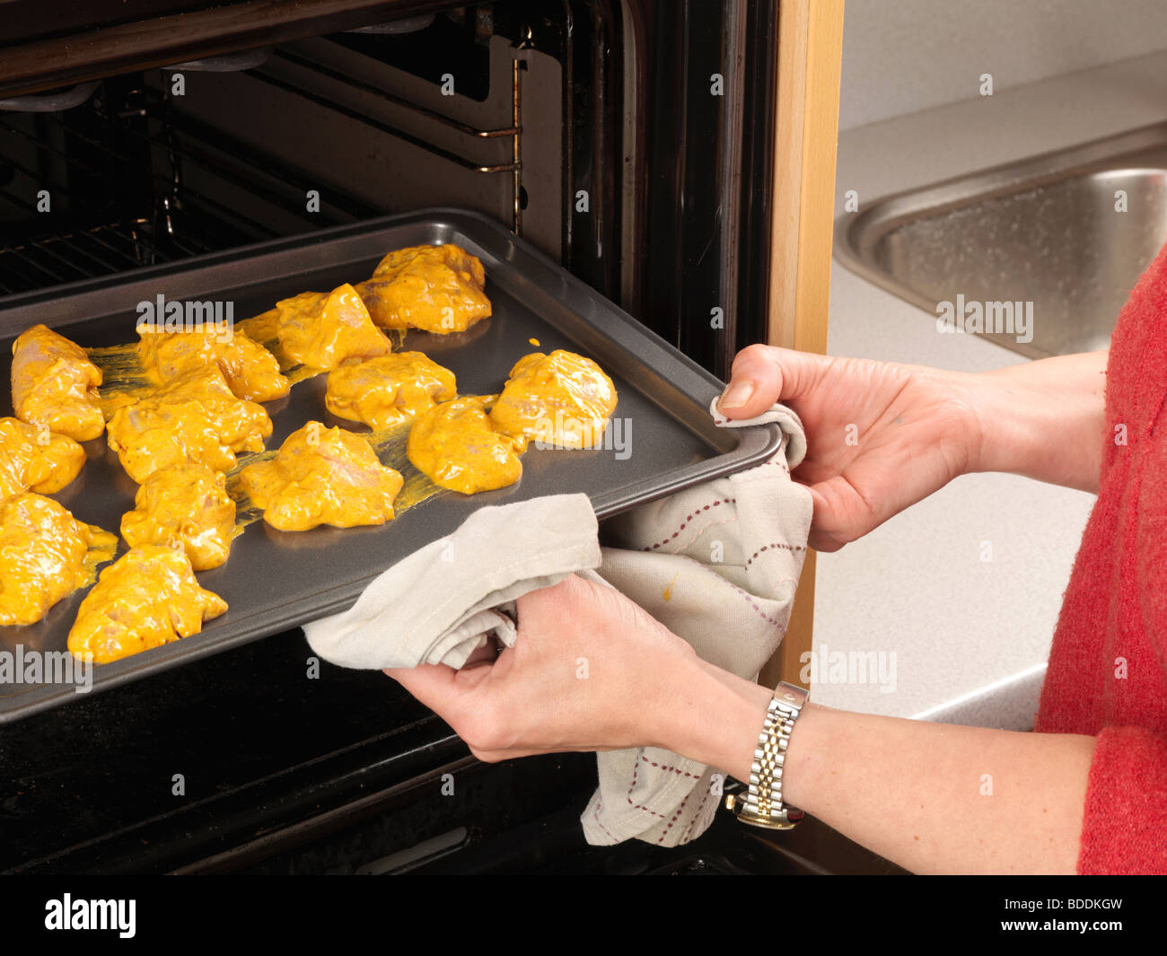 Donna di prendere una teglia con cena dal forno a microonde. La cottura per  un concetto Foto stock - Alamy