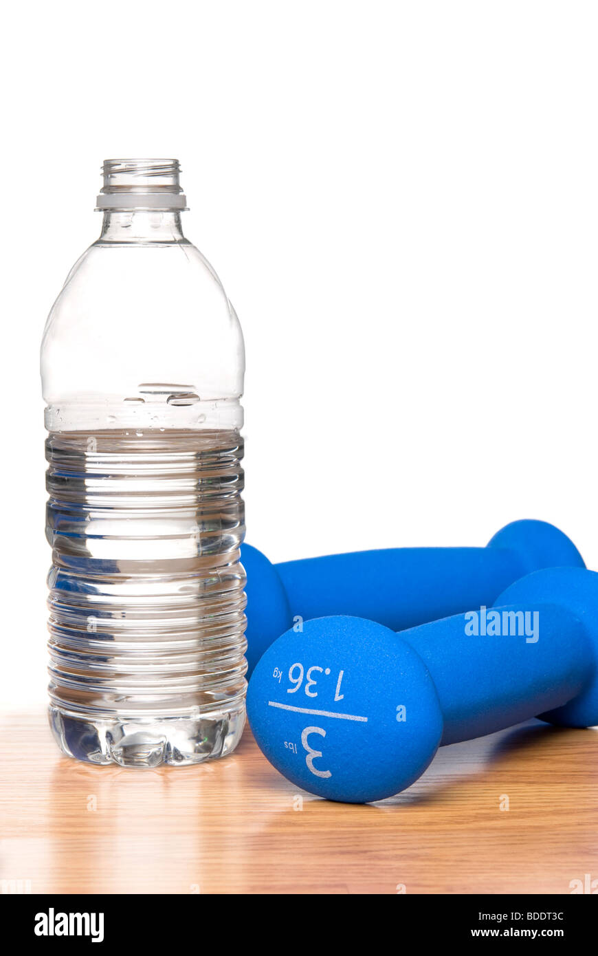 Una immagine concettuale di stili di vita sani con una bottiglia di acqua e manubri su uno sfondo bianco. Foto Stock