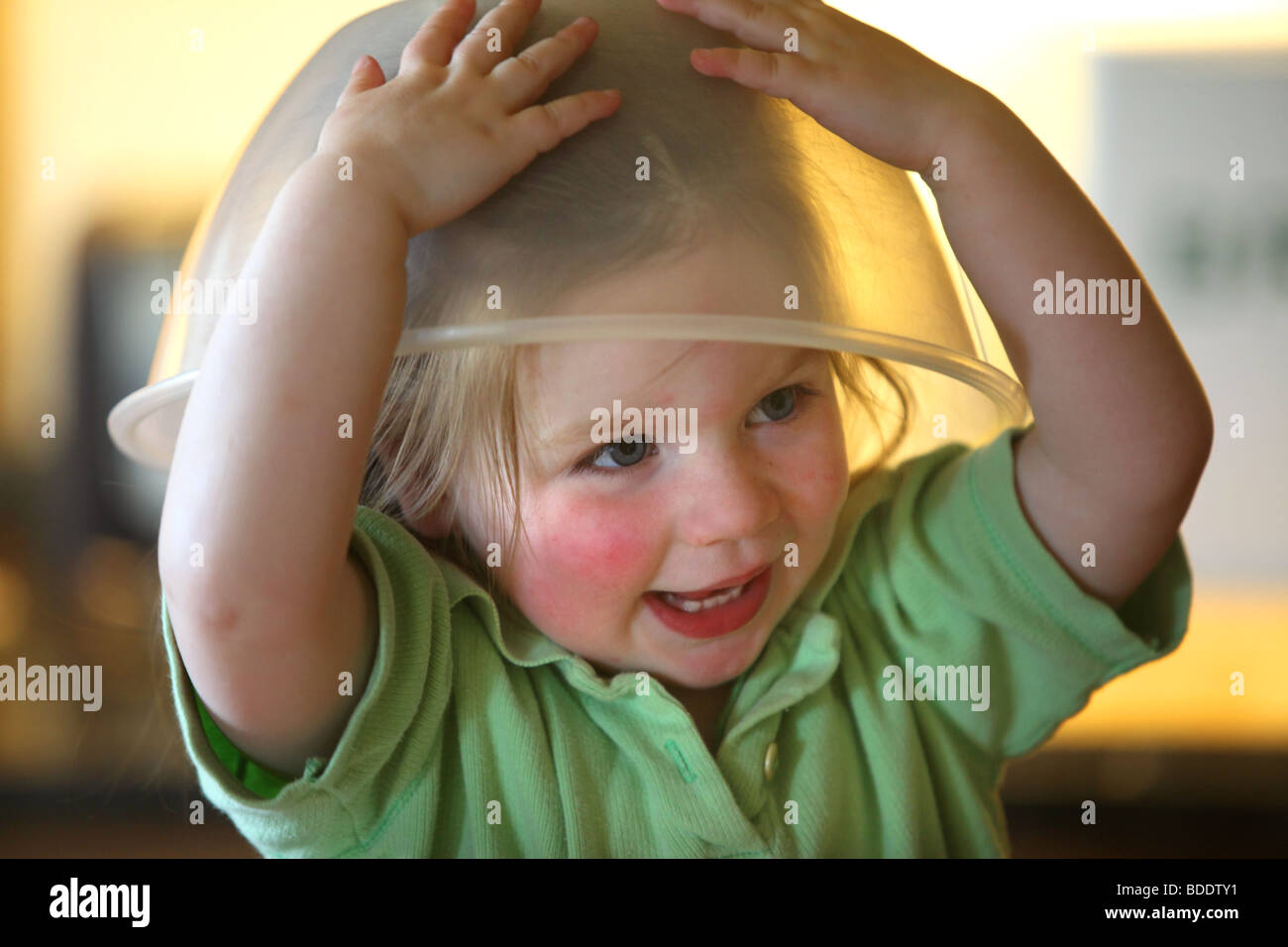 Bambino di 2 anni con il recipiente di miscelazione sul suo capo. Foto Stock