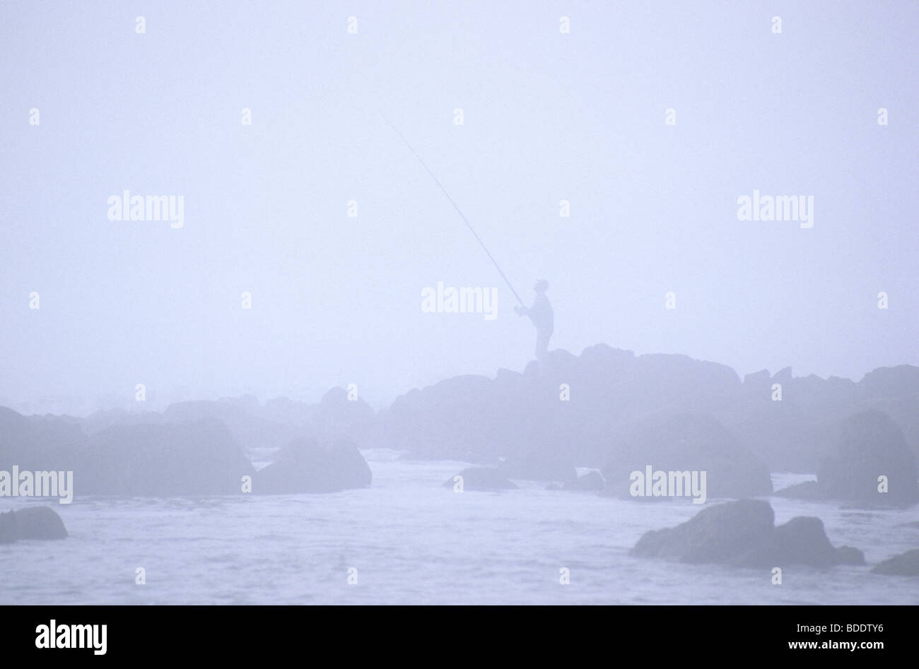 L'uomo fising nella nebbia. Mirleft, sud del Marocco. Foto Stock