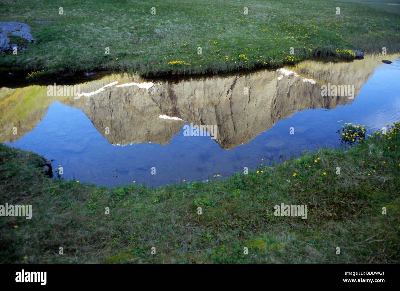 Calma stagno riflettente le suggestive montagne sopra la valle Horseid sull isola Moskensoya nelle Lofoten artico della Norvegia. Foto Stock