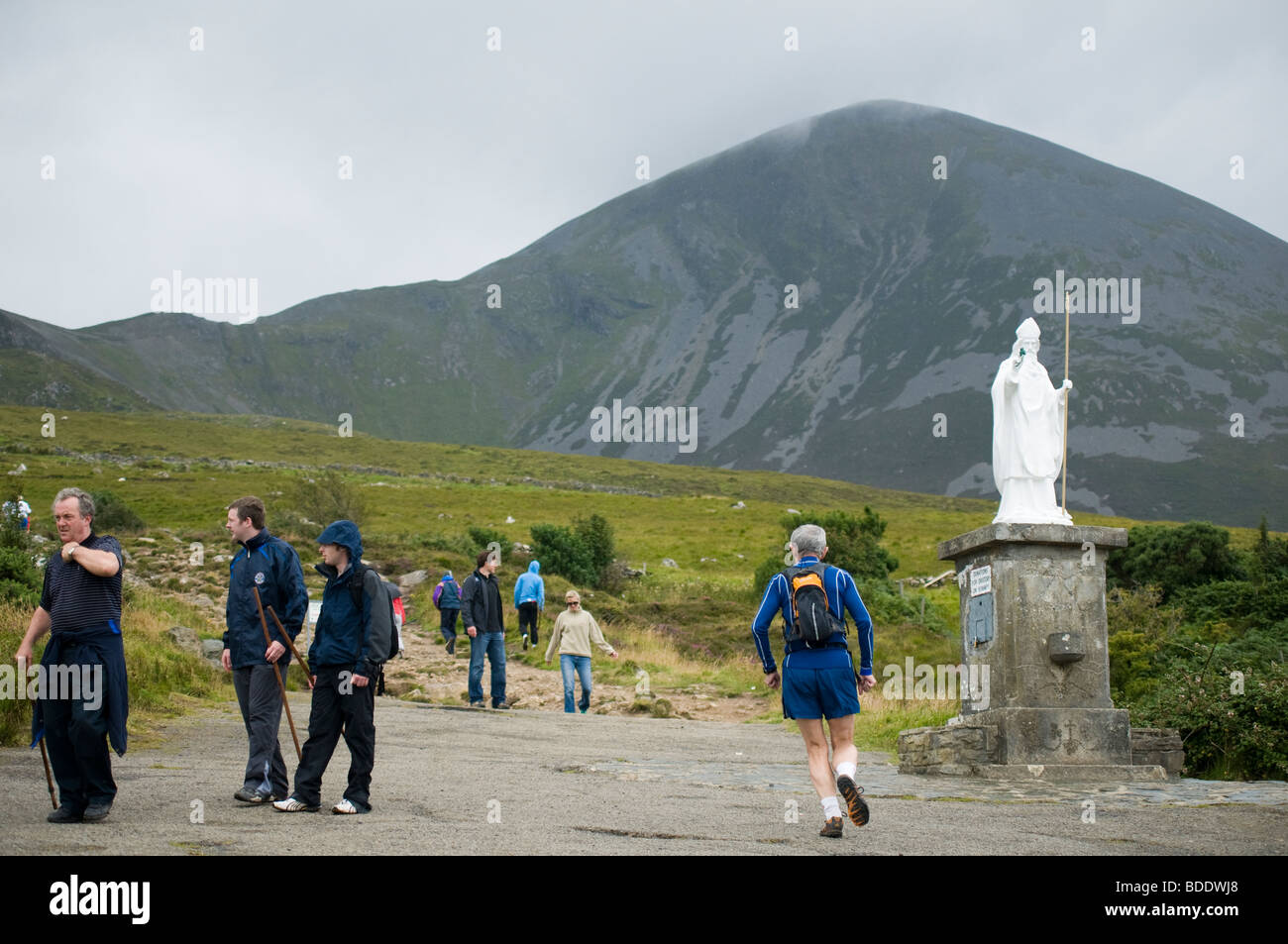 Pellegrini presso la statua di San Patrizio alla base del pellegrinaggio di montagna Croagh Patrick vicino a Westport County Mayo Irela Foto Stock