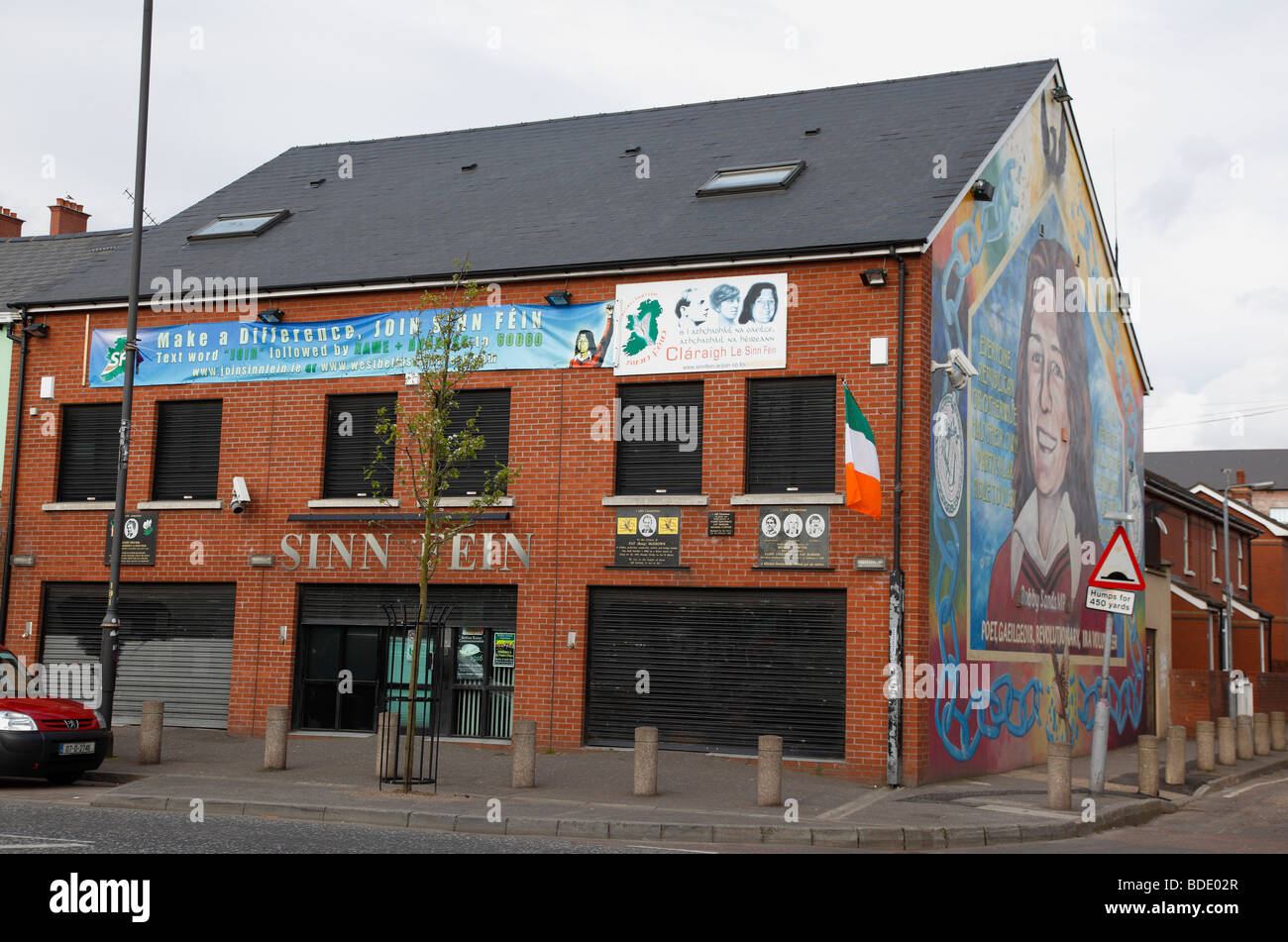 In Irlanda del Nord, Belfast, West, Falls Road, murale di Bobby Sands sul frontone del Sinn Fein sede sull'angolo di Foto Stock
