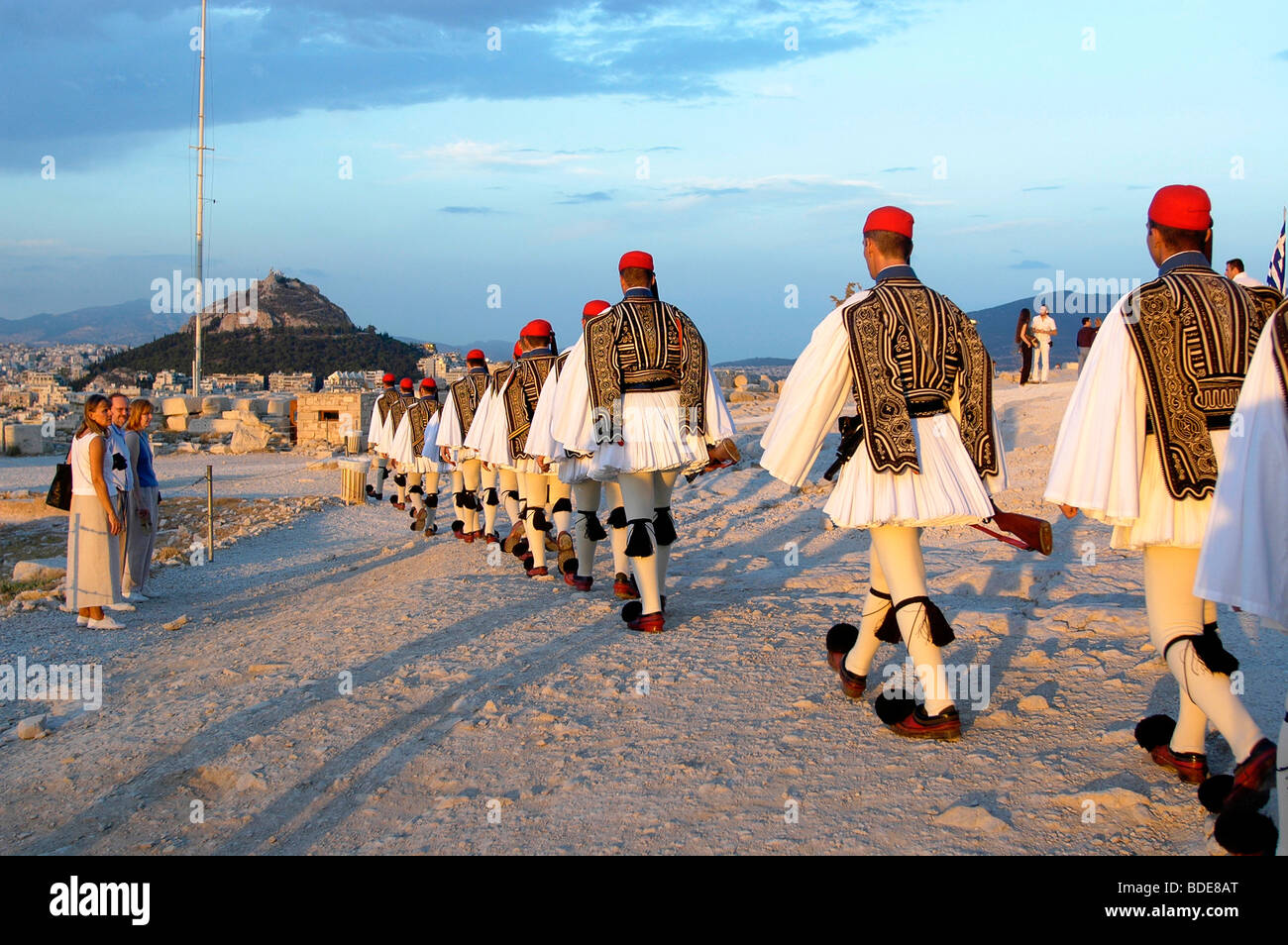 Evzonoi, greco guardie presidenziali, marciando a bandiera post. Ogni domenica la Evzonoi ammainare la bandiera da Acropolis. Foto Stock