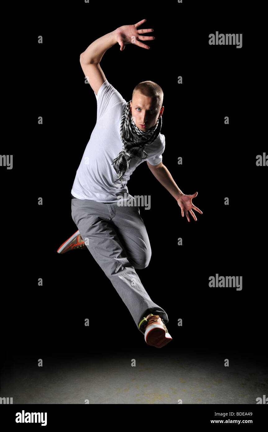 Hip hop dancer saltando su uno sfondo scuro Foto Stock