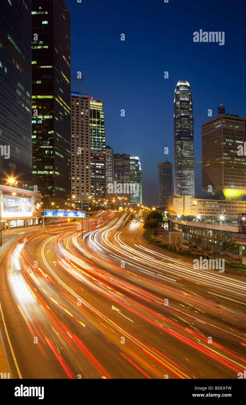 Un edificio alto e sentieri per auto a notte nel centro di Hong Kong, Cina. Foto Stock