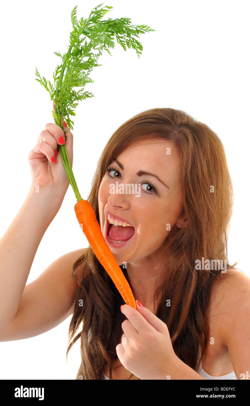 La carota, donna circa a prendere un boccone fuori di una carota Foto Stock