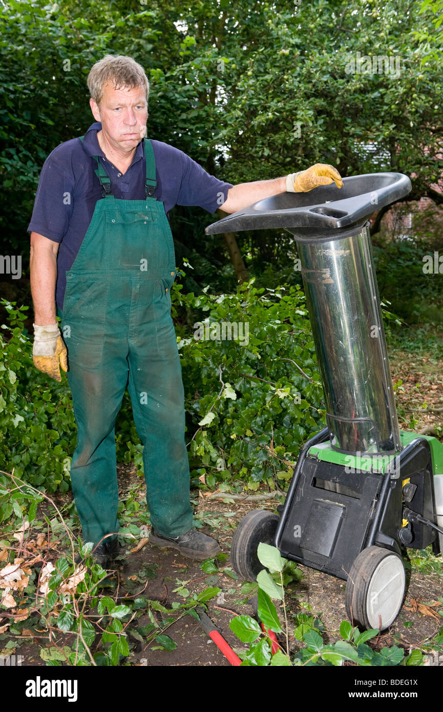 Di mezza età lavoratore forestale con trinciatrice Foto Stock