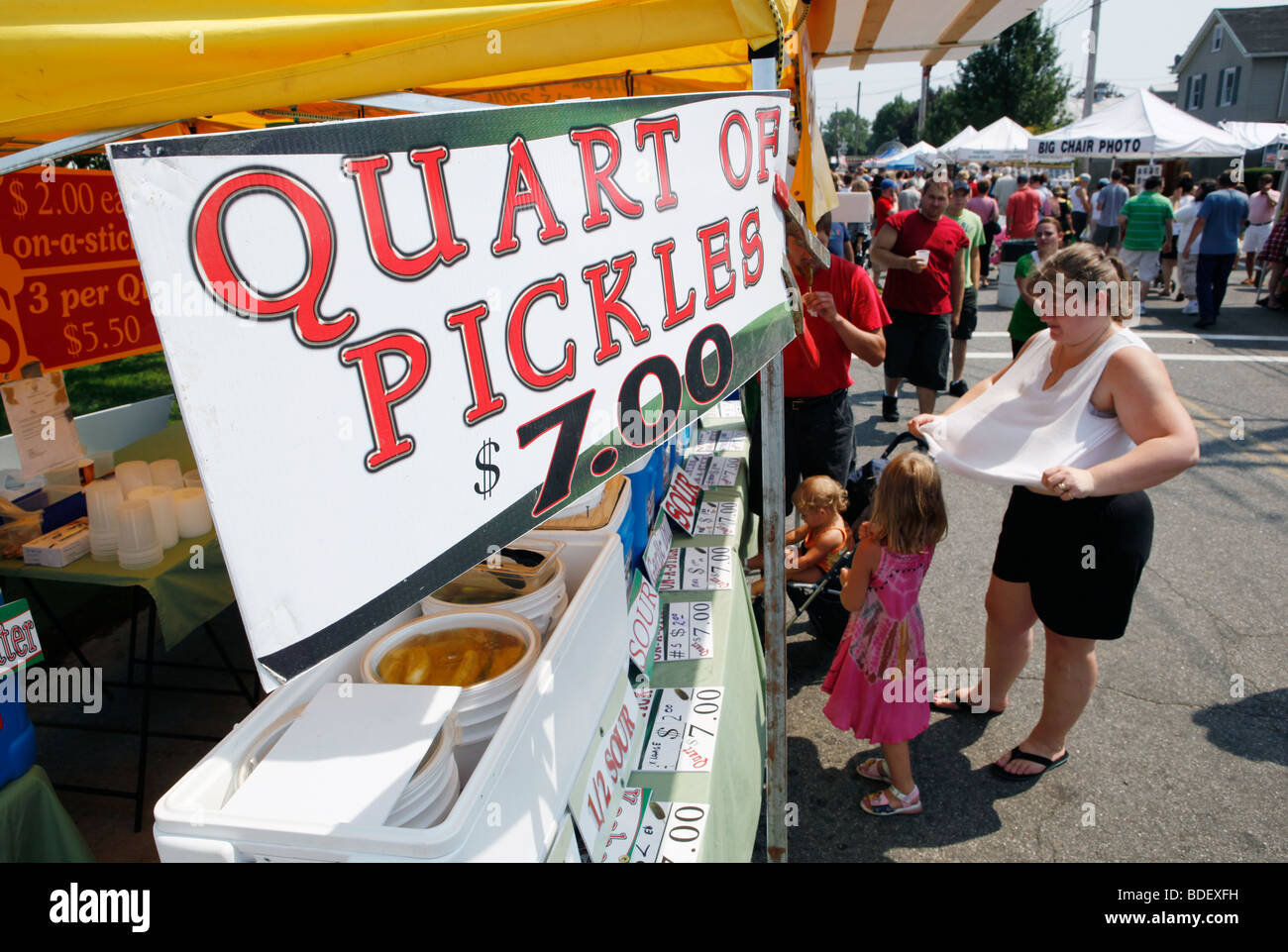 Una donna fan se stessa nel calore ad un'estate street fair, Long Island, New York Foto Stock