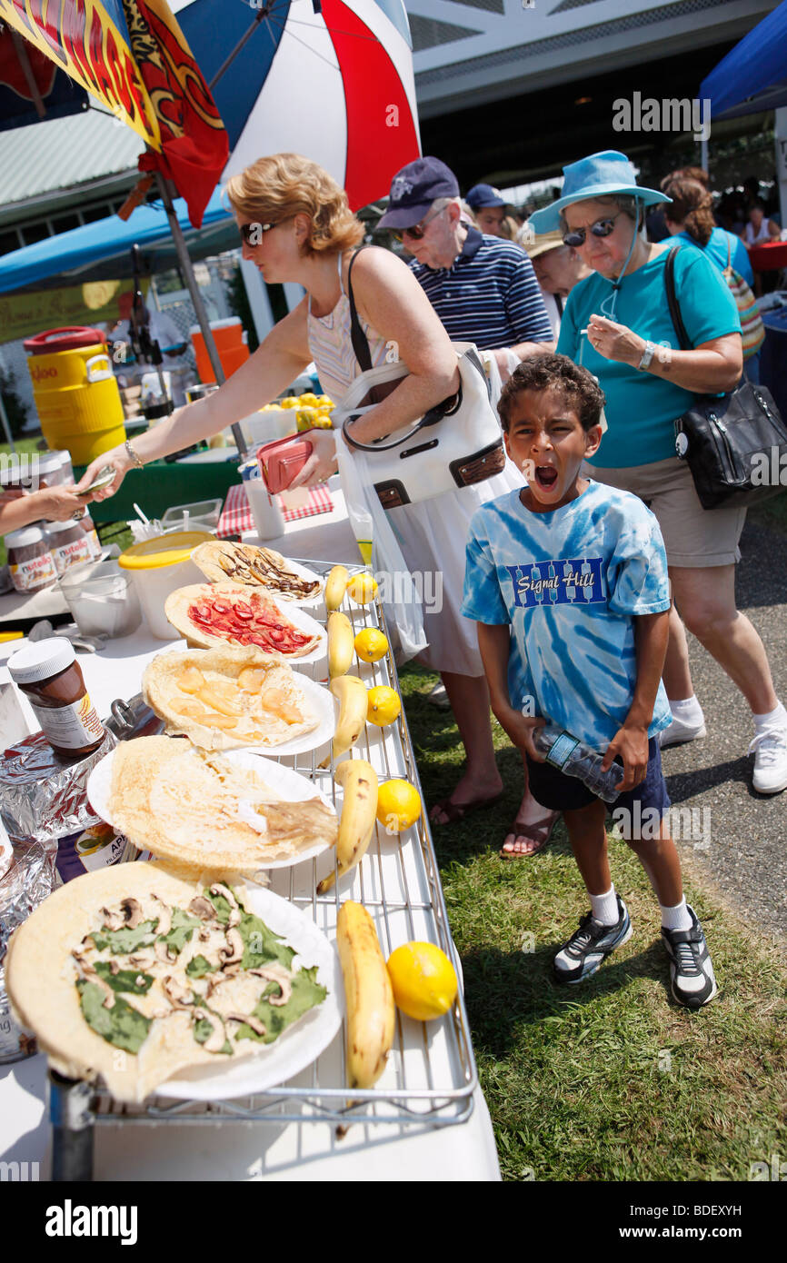 Un ragazzo sbadigli, estate street fair, Long Island, New York Foto Stock