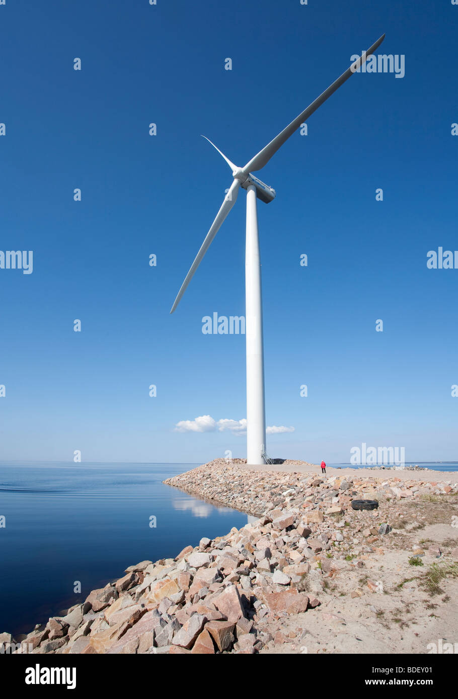 Piccolo essere umano al di sotto di una massiccia, alto turbina eolica , Finlandia Foto Stock