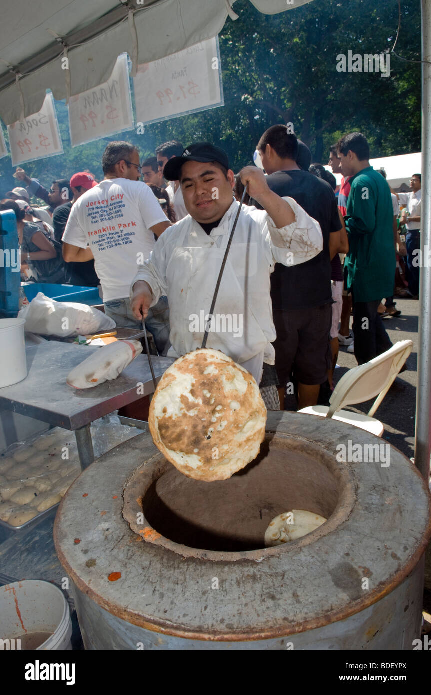 Un lavoratore ispanica cuoce pane indiano al festival all'Indian Independence Day Parade di New York Foto Stock