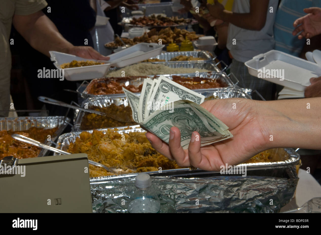 Un cliente paga per il tradizionale cibo indiano al festival presso l'indipendenza indiana parata del giorno su Madison Avenue a New York Foto Stock