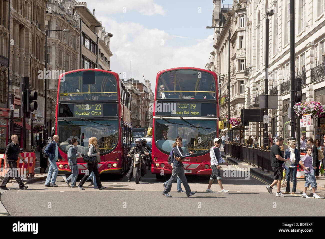 Due red double decker bus di Londra in attesa per i pedoni a strisce pedonali per accedere a Piccadilly Circus, a Londra Foto Stock