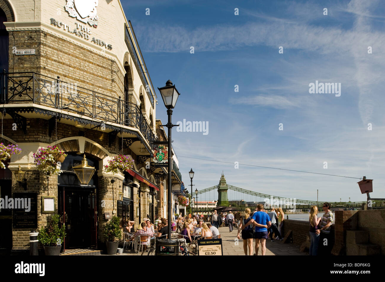 Le persone a rilassarsi in pub ovrlooking fiume Thames, Hammersmith, W6, London, Regno Unito Foto Stock