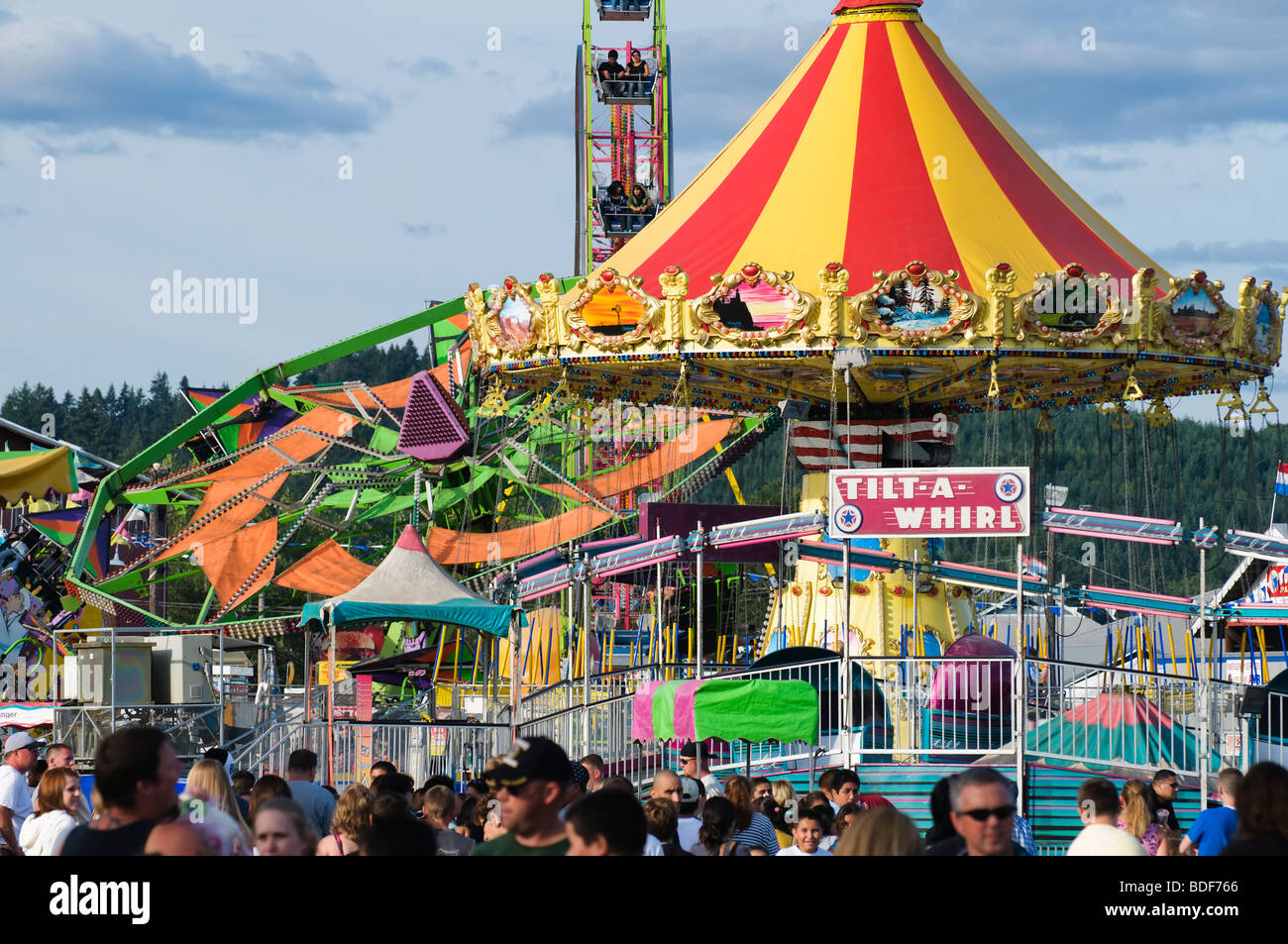 Parco dei divertimenti di giostre e una folla di persone a livello locale contea fiera d'estate. Foto Stock