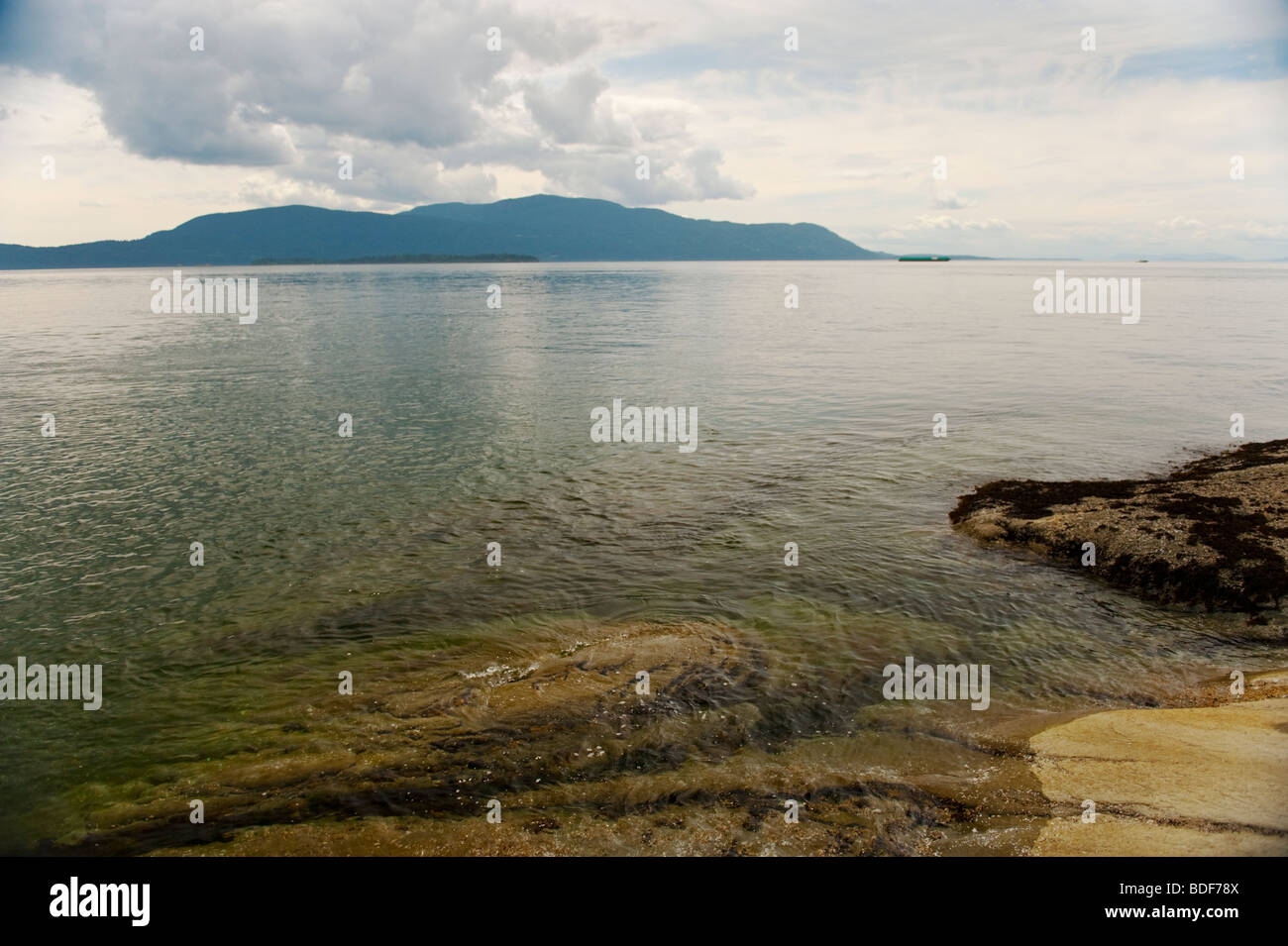 Bella Orcas Island può essere visto attraverso lo Stretto di Rosario, da una spiaggia sul lato ovest di Lummi Island, Washington, Stati Uniti d'America. Foto Stock