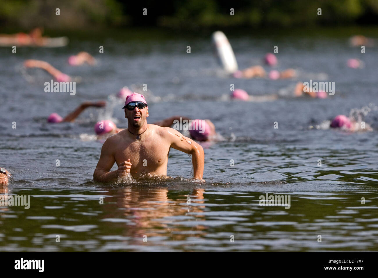 Triatleta lascia l'acqua dopo la nuotata gamba di un Xterra triathlon. Foto Stock