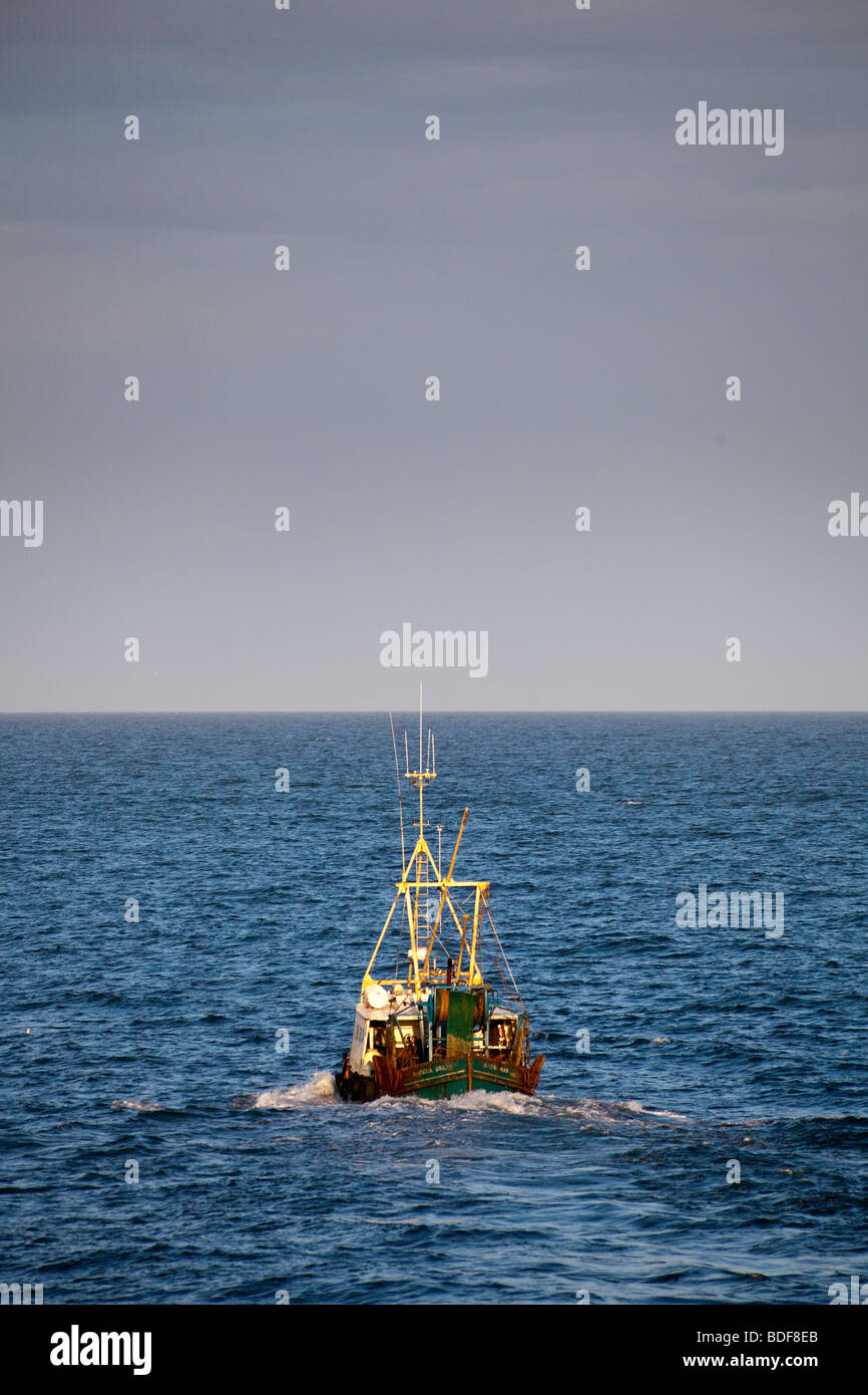 La pesca a strascico lasciando Ardglass porto al crepuscolo Foto Stock