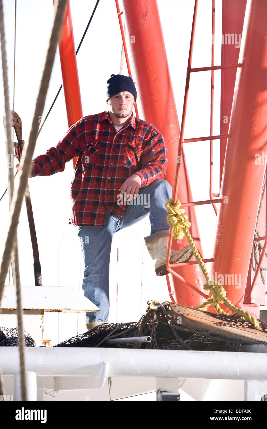 Giovane pescatore in plaid shirt su barca da pesca Foto Stock