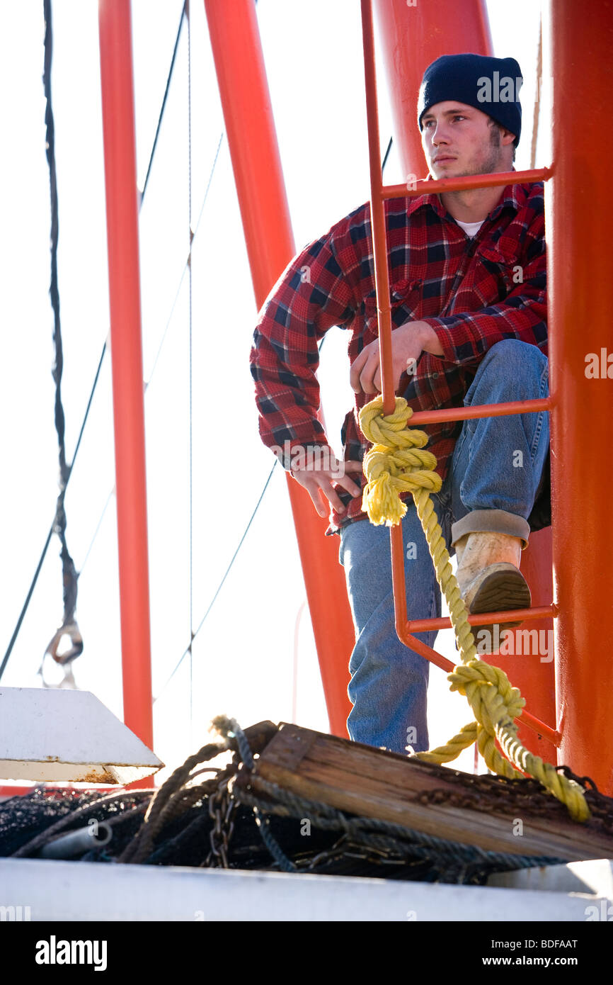 Giovane pescatore in plaid shirt su barca da pesca Foto Stock