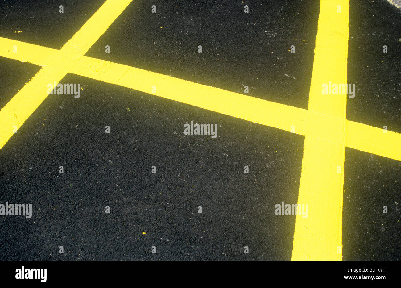 Fresche linee gialla dipinta sul recente superficie asfaltata come parte di un parcheggio non o nessuna griglia di attesa Foto Stock