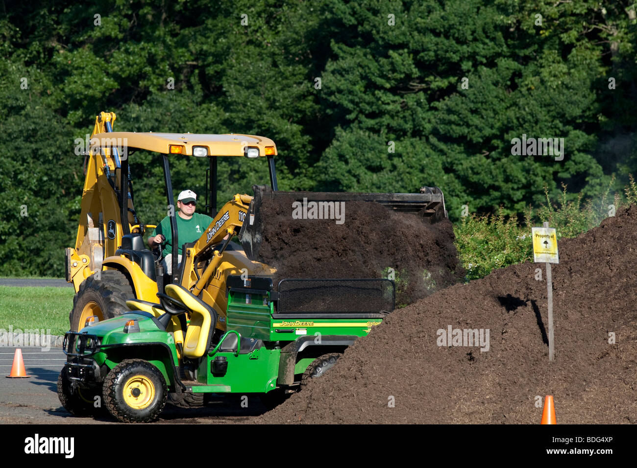 La pacciamatura in movimento con un trattore John Deere e veicolo utilitario. Foto Stock