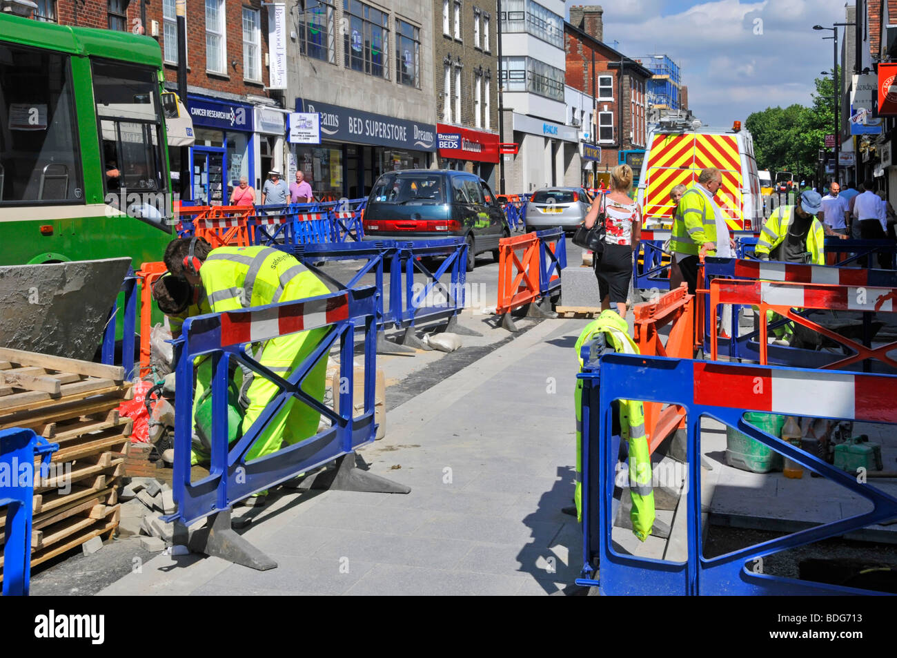 Brentwood shopping alta strada lavori operai in giacche ad alta visibilità miglioramento strada e marciapiede disturbare il traffico e pedoni Essex Inghilterra Foto Stock