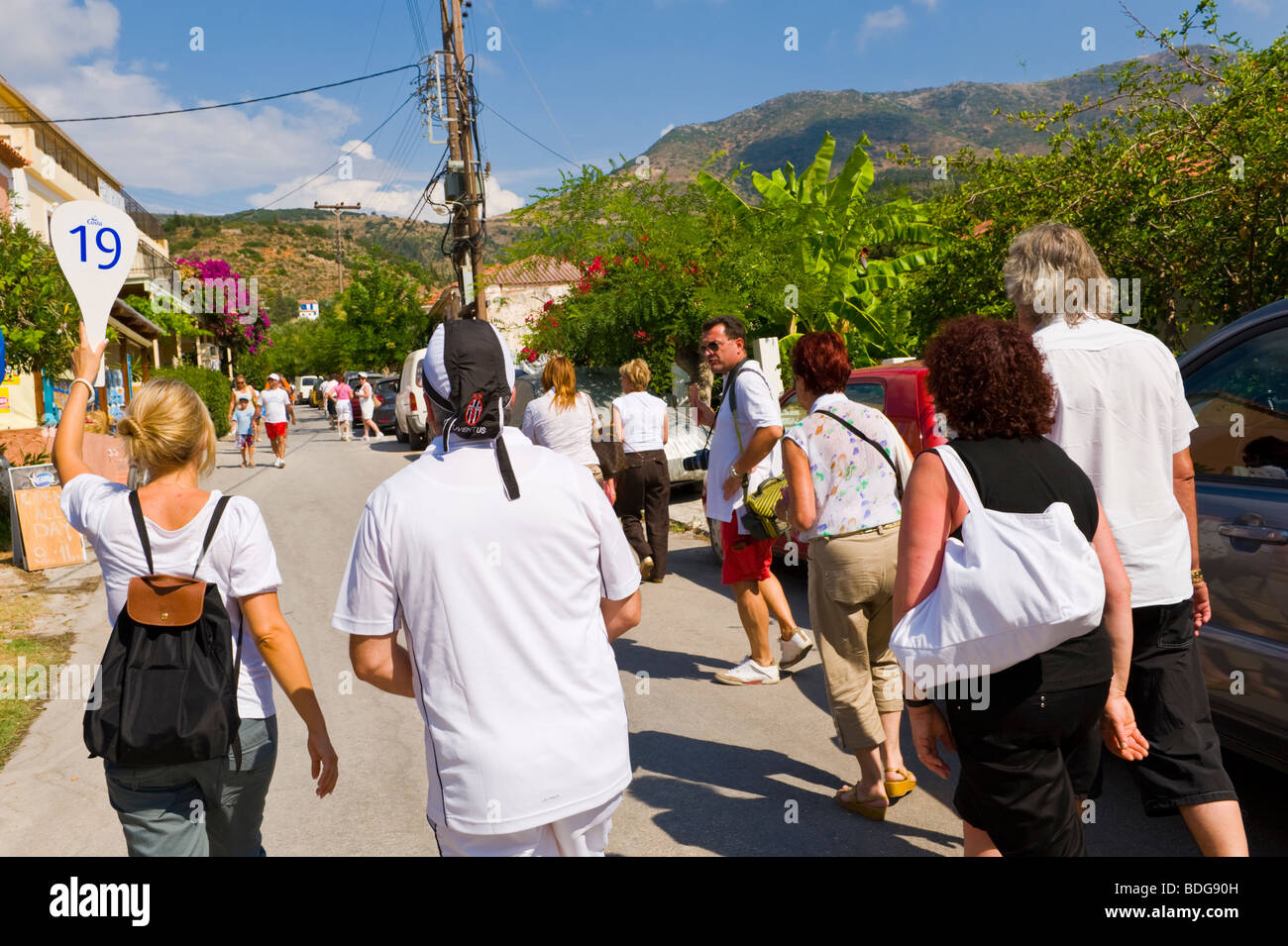 Organizzati tour di gruppo con guida 19 camminando attraverso il villaggio di Assos sul Mediterraneo greca isola di Cefalonia in Grecia GR Foto Stock
