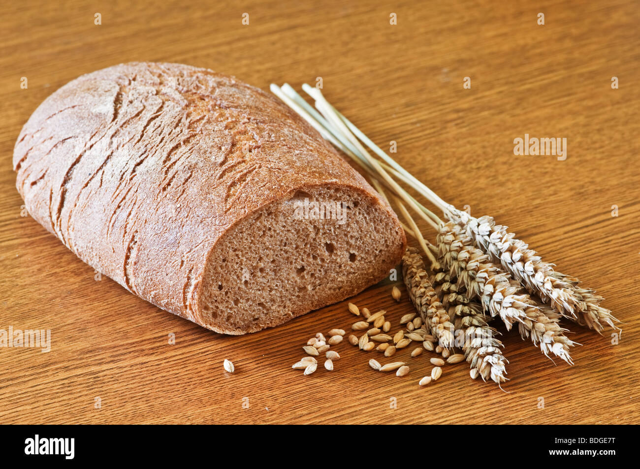 Pane con grano su tavola di legno Foto Stock