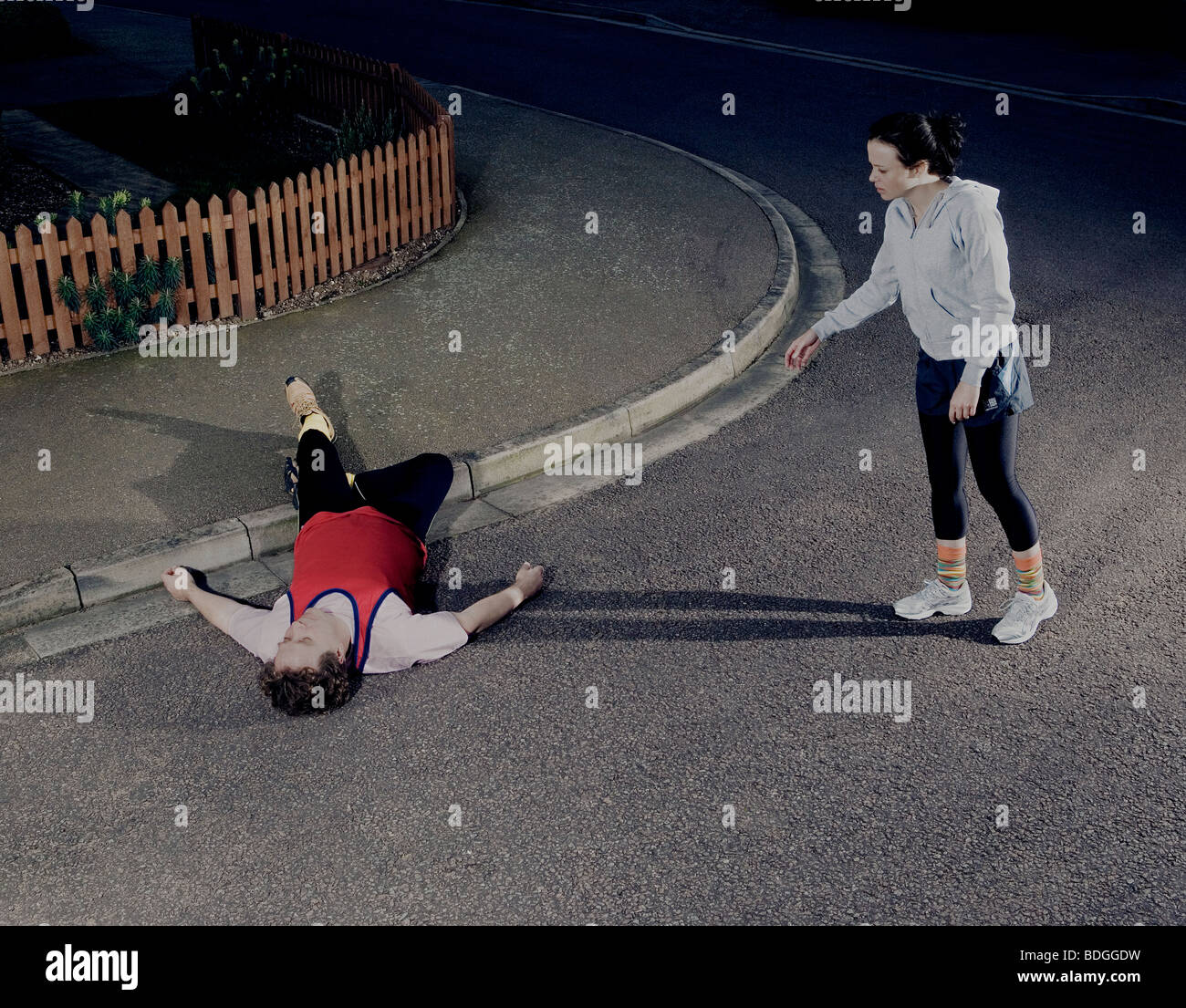 Pareggiatore femmina sembra preoccupantemente in un pareggiatore maschio sdraiato sul pavimento avente crollato durante la corsa Foto Stock