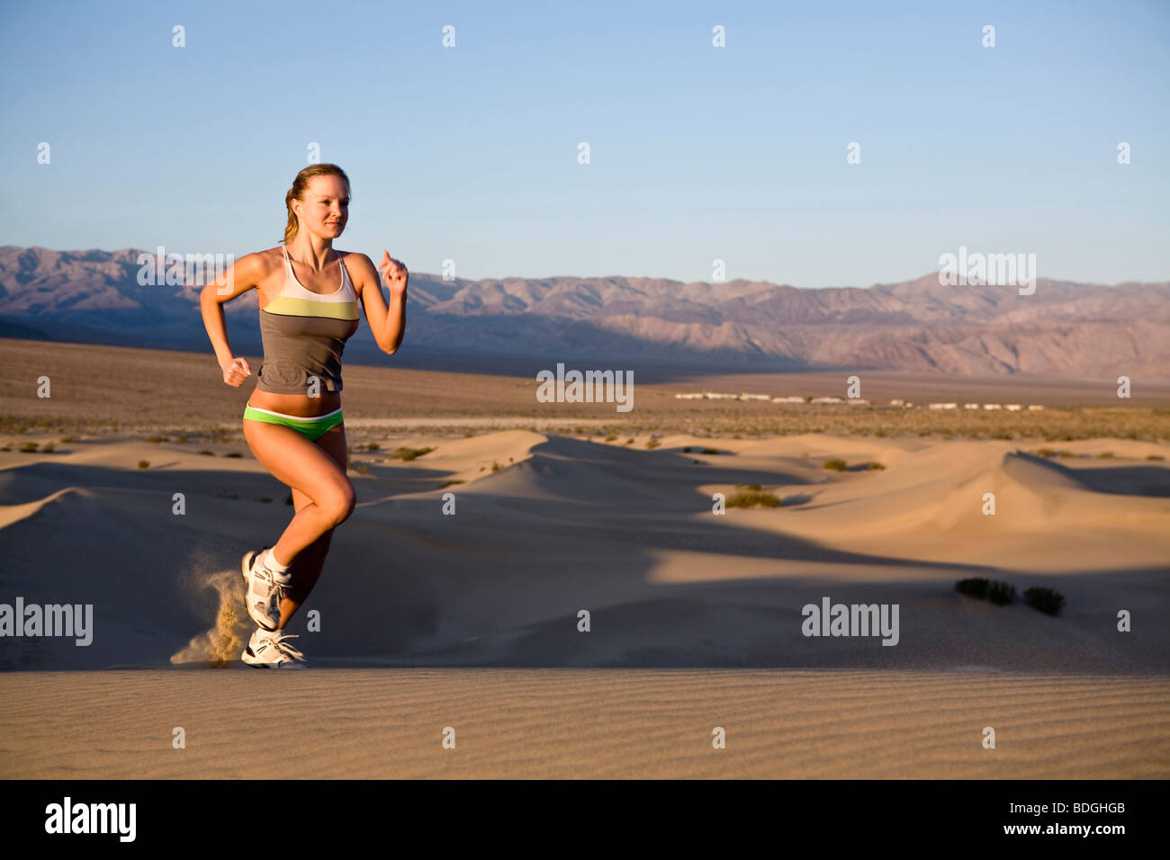 Una giovane donna fuori per una corsa mattutina sul tubo da stufa pozzetti dune nella Death Valley, California. Foto Stock