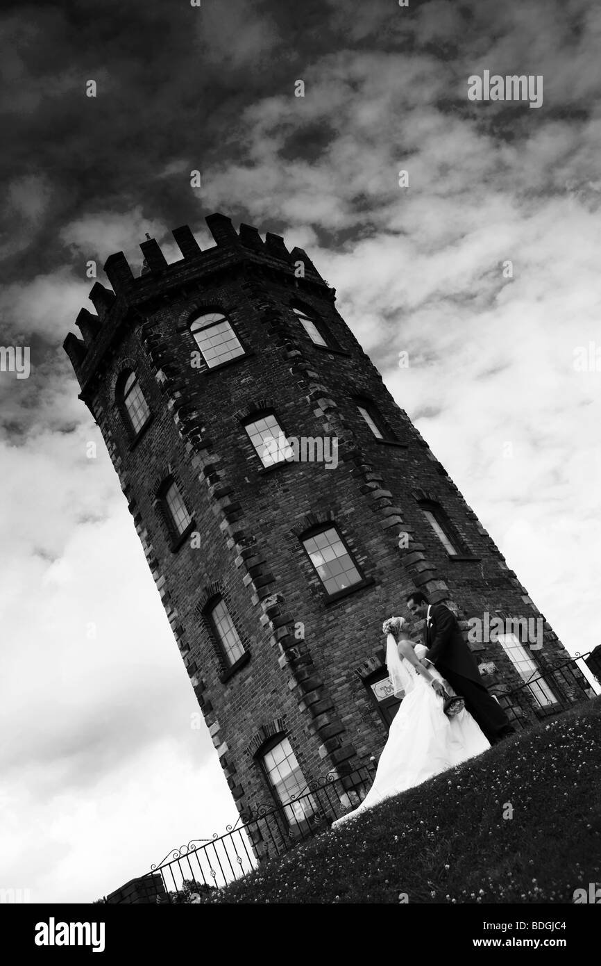 Sposa e lo sposo in piedi un fondo di torre scuro sul giorno di nozze moderna fotografia di matrimonio Foto Stock