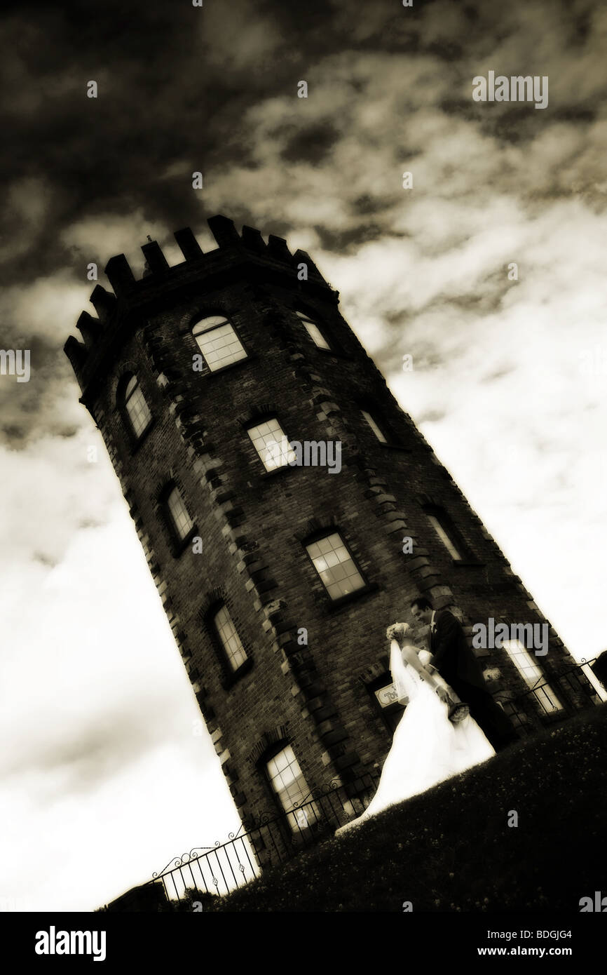 Sposa e lo sposo in piedi un fondo di torre scuro sul giorno di nozze moderna fotografia di matrimonio Foto Stock