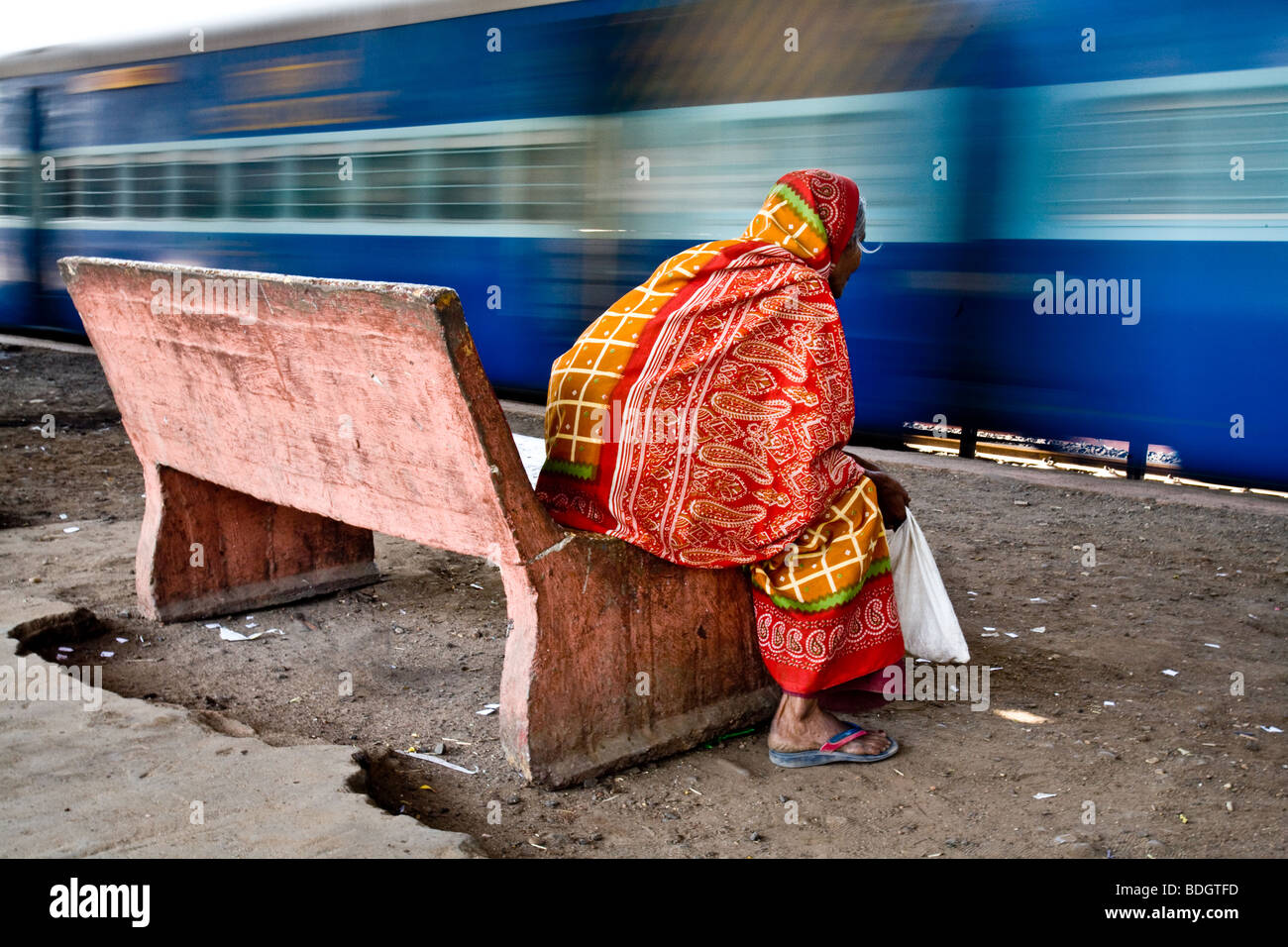 Le donne in attesa che il suo treno in corrispondenza di una stazione ferroviaria in India mentre un altro treno passa da. Foto Stock
