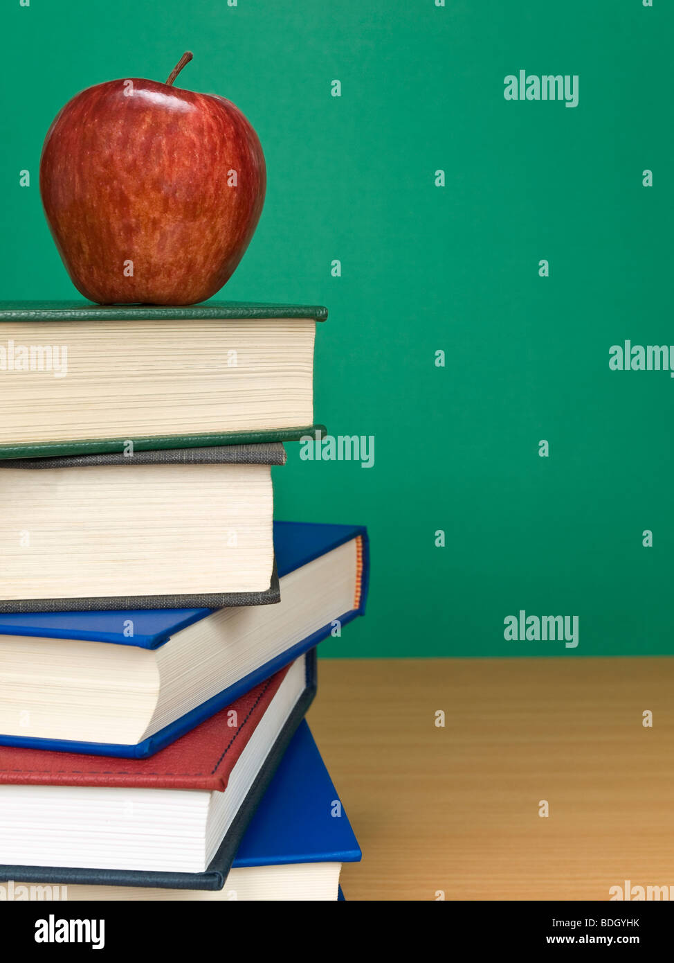 Una lavagna vuota con un Apple sulla sommità di una pila di libri. Foto Stock