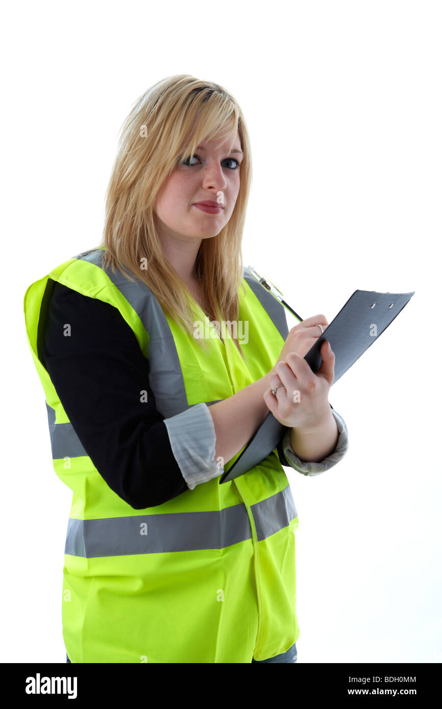giovane donna bionda di 20 anni che indossa gilet ad alto visibilità scrivere note su un clipboard occhio contatto supervisore controllo fare note registrazione valutazione Foto Stock