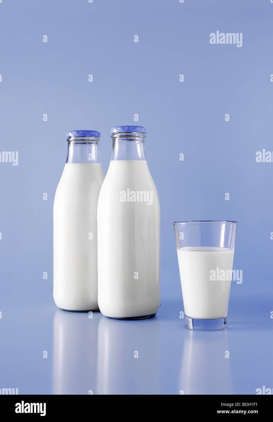 Due bottiglie di latte e un bicchiere di latte Foto Stock