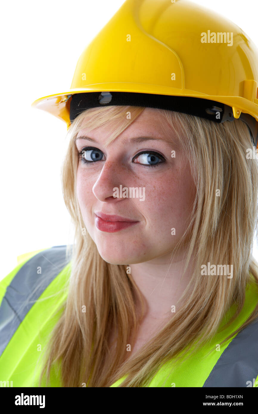 I giovani di 20 anni donna bionda indossare casco giallo e alta vis vest sorridente con il contatto visivo Foto Stock