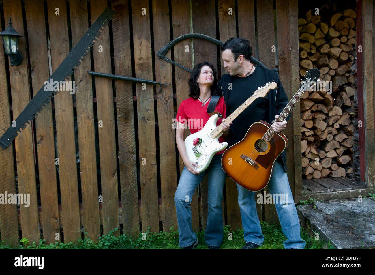 Paese occidentale chitarristi matura guardando teneramente - boschi sparso come sfondo Foto Stock