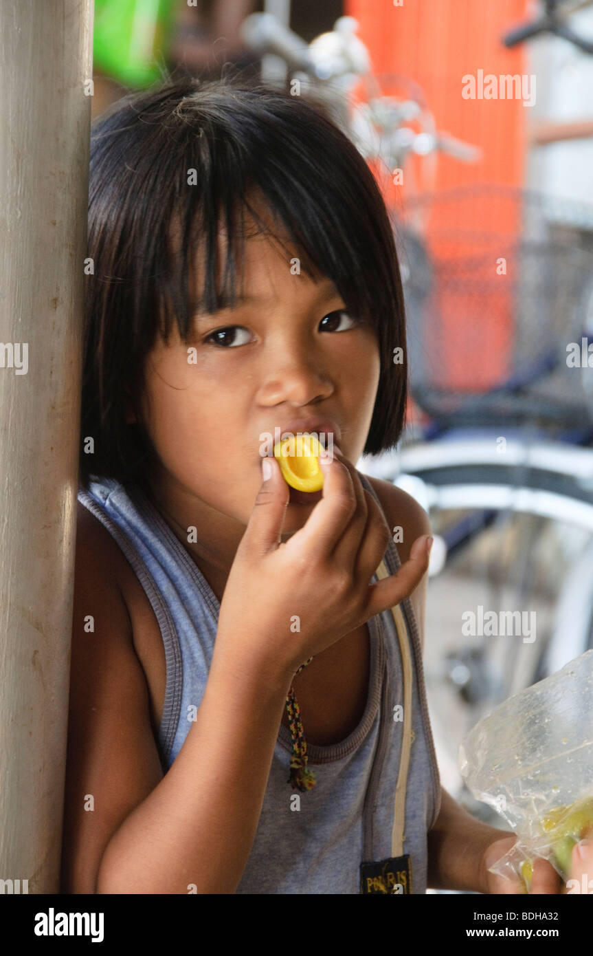 Ragazza mangia frutto amaro a Bangkok in Tailandia Foto Stock