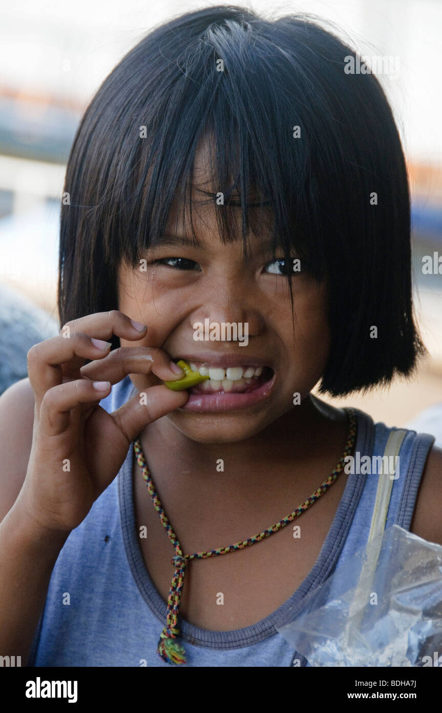 Ragazza mangia frutto amaro a Bangkok in Tailandia Foto Stock