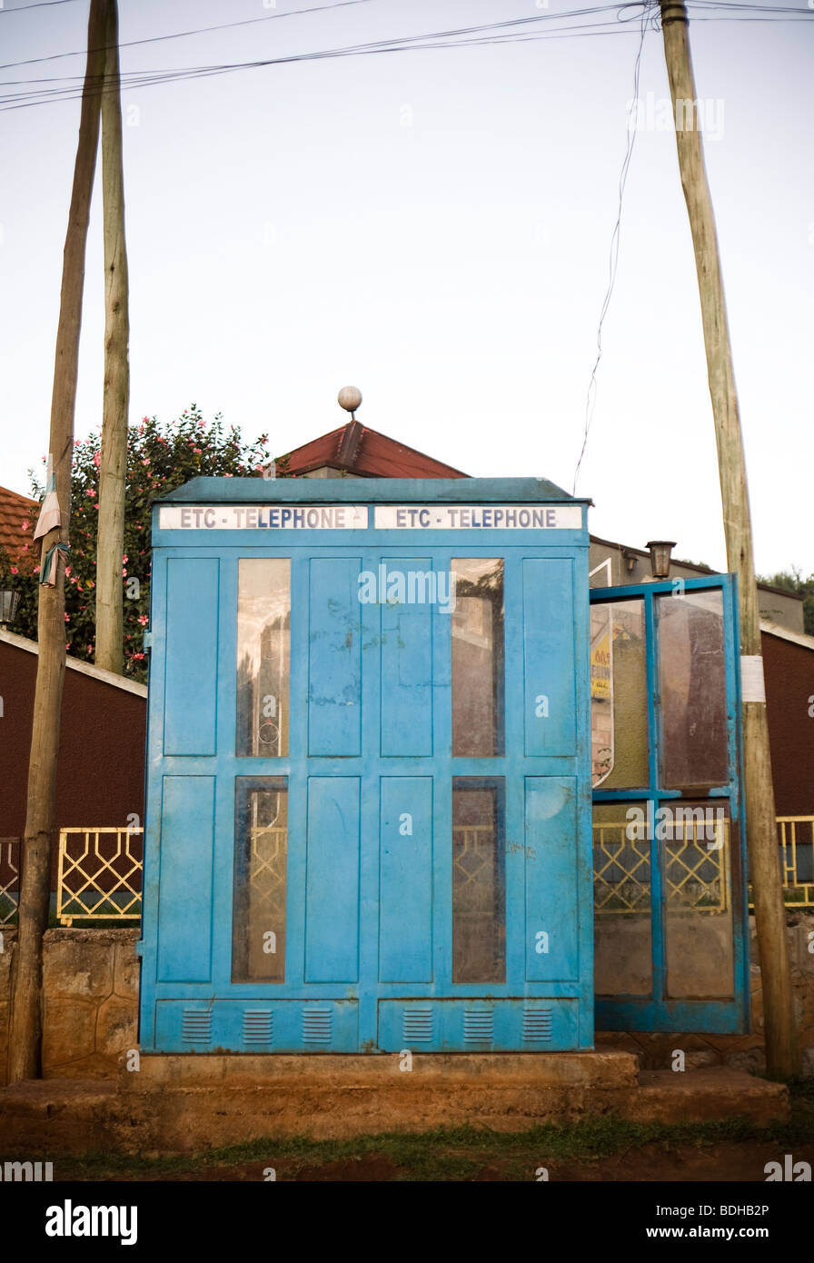 Un vecchio blu brillante cabina telefonica si trova al di sotto di linee di alimentazione. Foto Stock