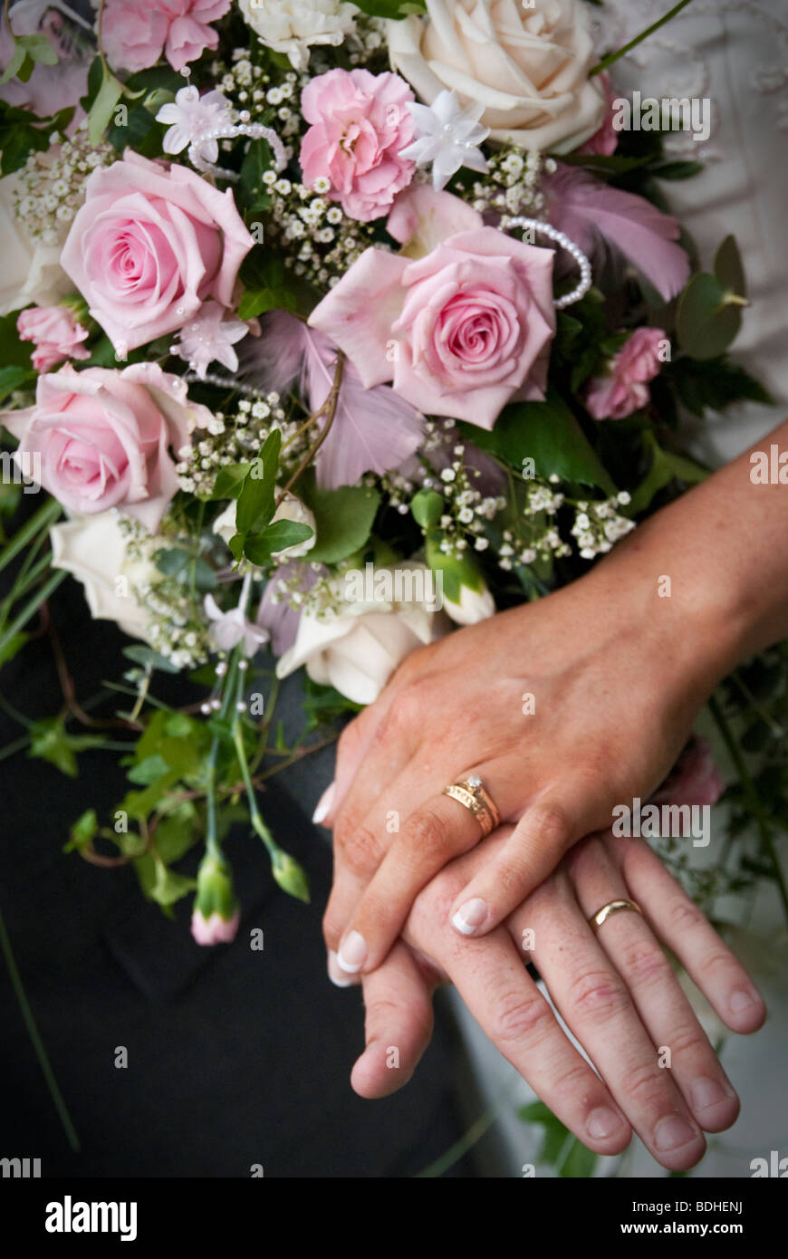 Gli anelli di nozze su mani della sposa e lo sposo con bouquet di fiori  Foto stock - Alamy