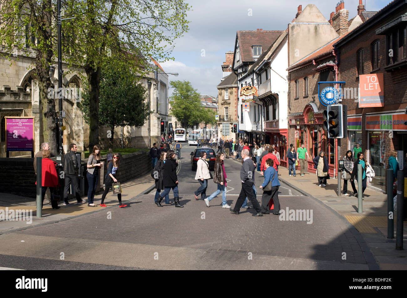 Pedoni attraversare la strada al semaforo nel centro di York, Inghilterra Foto Stock