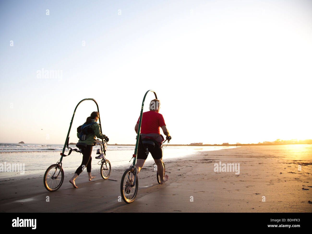 Una nuova forma di bicicletta è testato sulla spiaggia al tramonto. Foto Stock