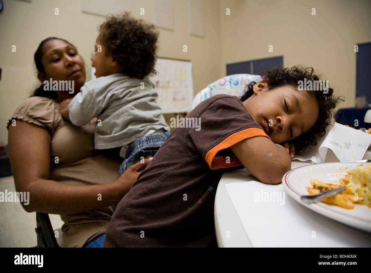 Selena Pina, una casa madre di quattro e i suoi bambini stare in linea per ricevere la cena preparata dai volontari della promessa di famiglia Foto Stock