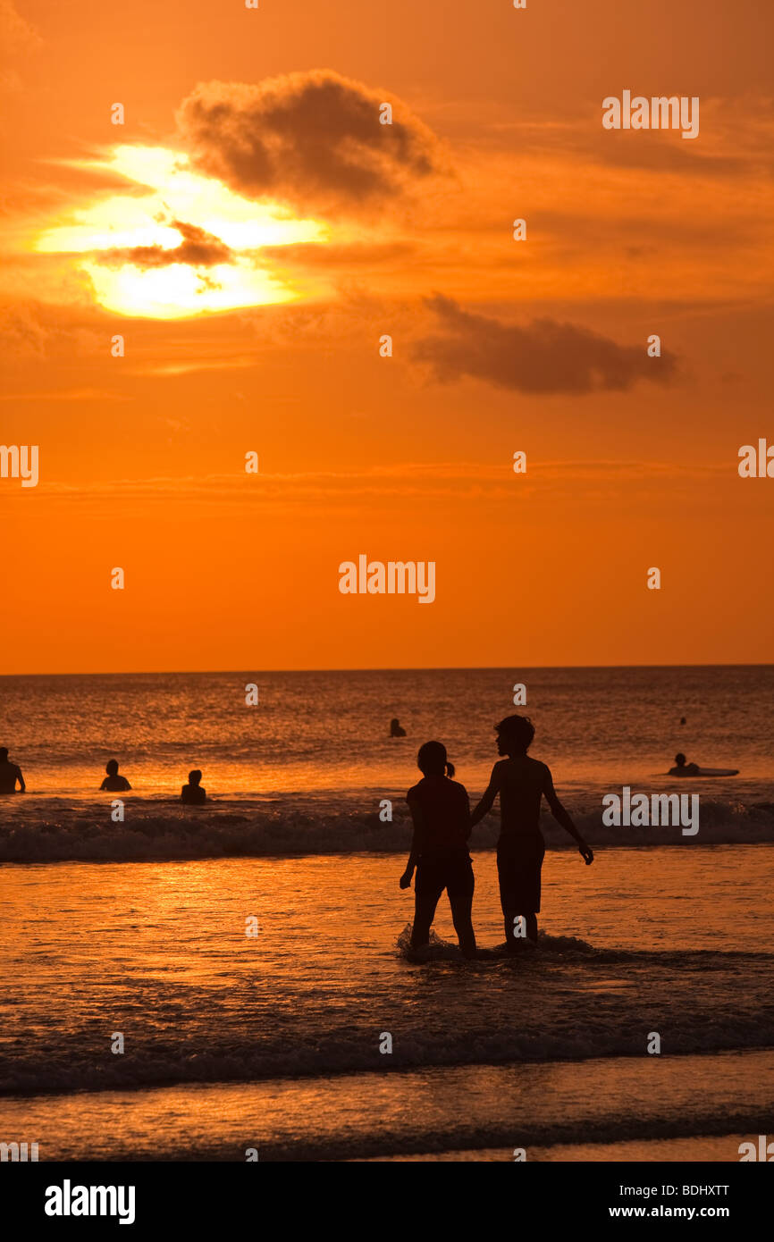 Indonesia Bali Kuta Beach, matura in acque poco profonde al tramonto Foto Stock