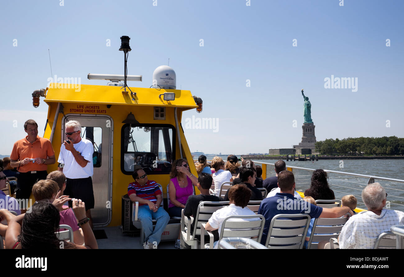 Un gruppo di turisti su un acqua taxi tour guidato per la Statua della Libertà, il fiume Hudson, New York City, Stati Uniti d'America. Foto Stock
