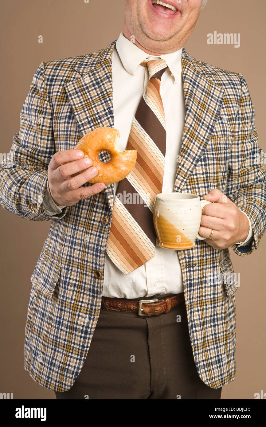 Imprenditore retrò mangiando una ciambella e bere una tazza di caffè Foto Stock